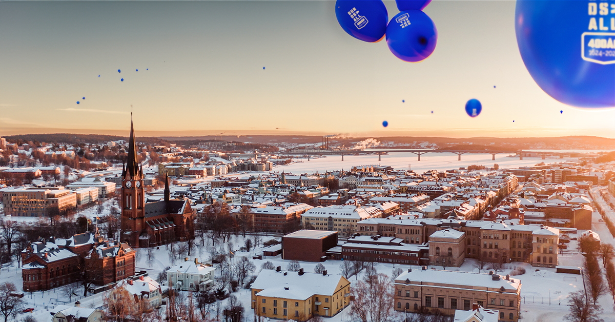 Sundsvalls stad i solnedgången och blåa ballonger som flyger i skyn.